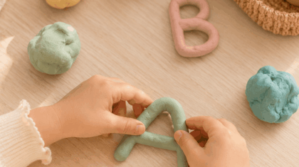 Kinderhände formen Buchstaben aus bunter Knete – Buchstaben lernen spielerisch vor der Schule