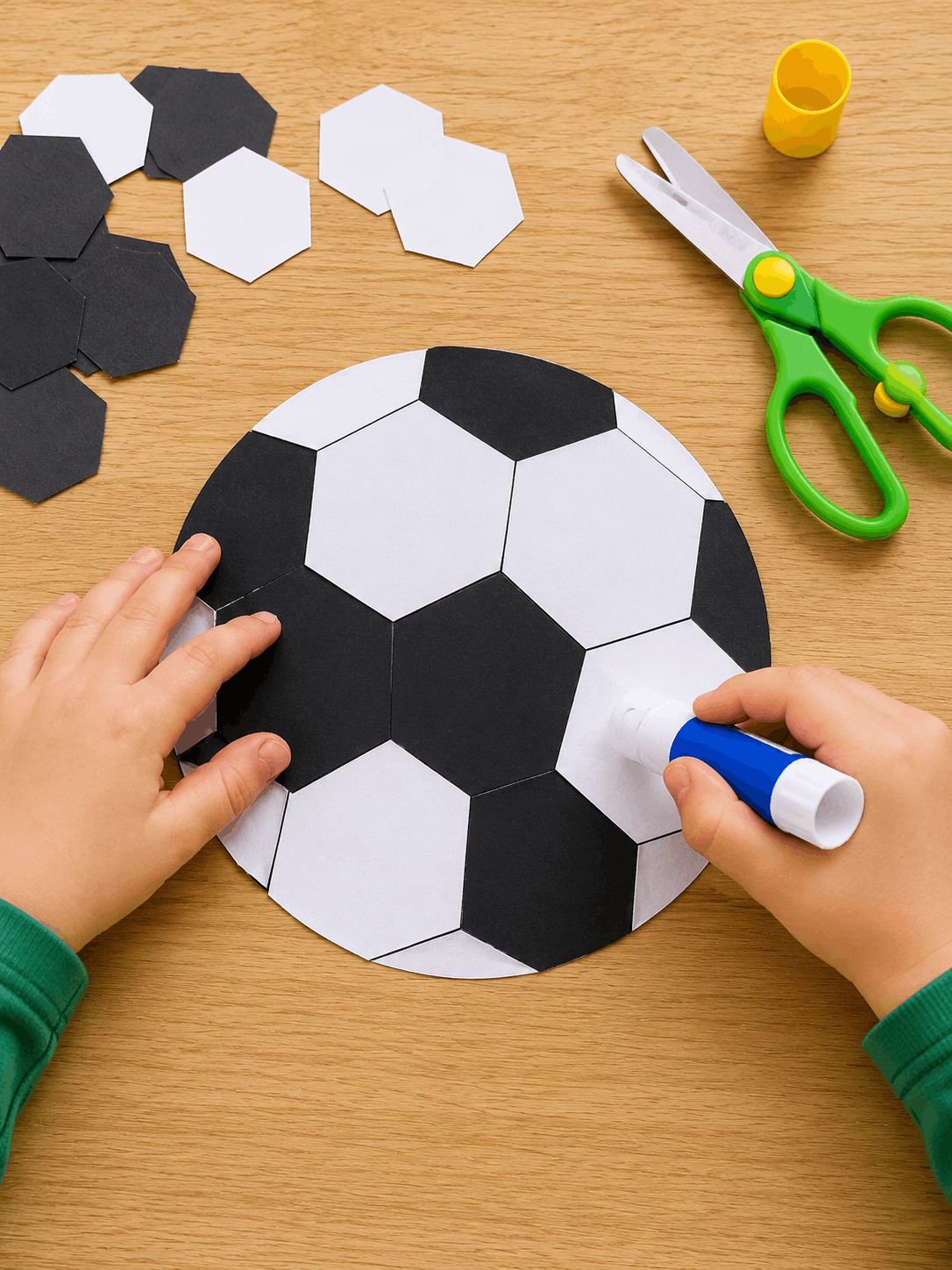 Fußball aus schwarzen und weißen Papier-Sechsecken kleben – Bastelidee für die Feinmotorik