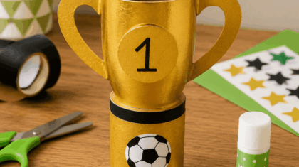 Kleiner selbstgebastelter Pokal aus Goldpapier und Papprolle – Fußball basteln mit Kindern